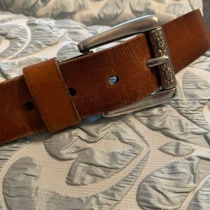 Brown Fossil leather belt with floral design on buckle.